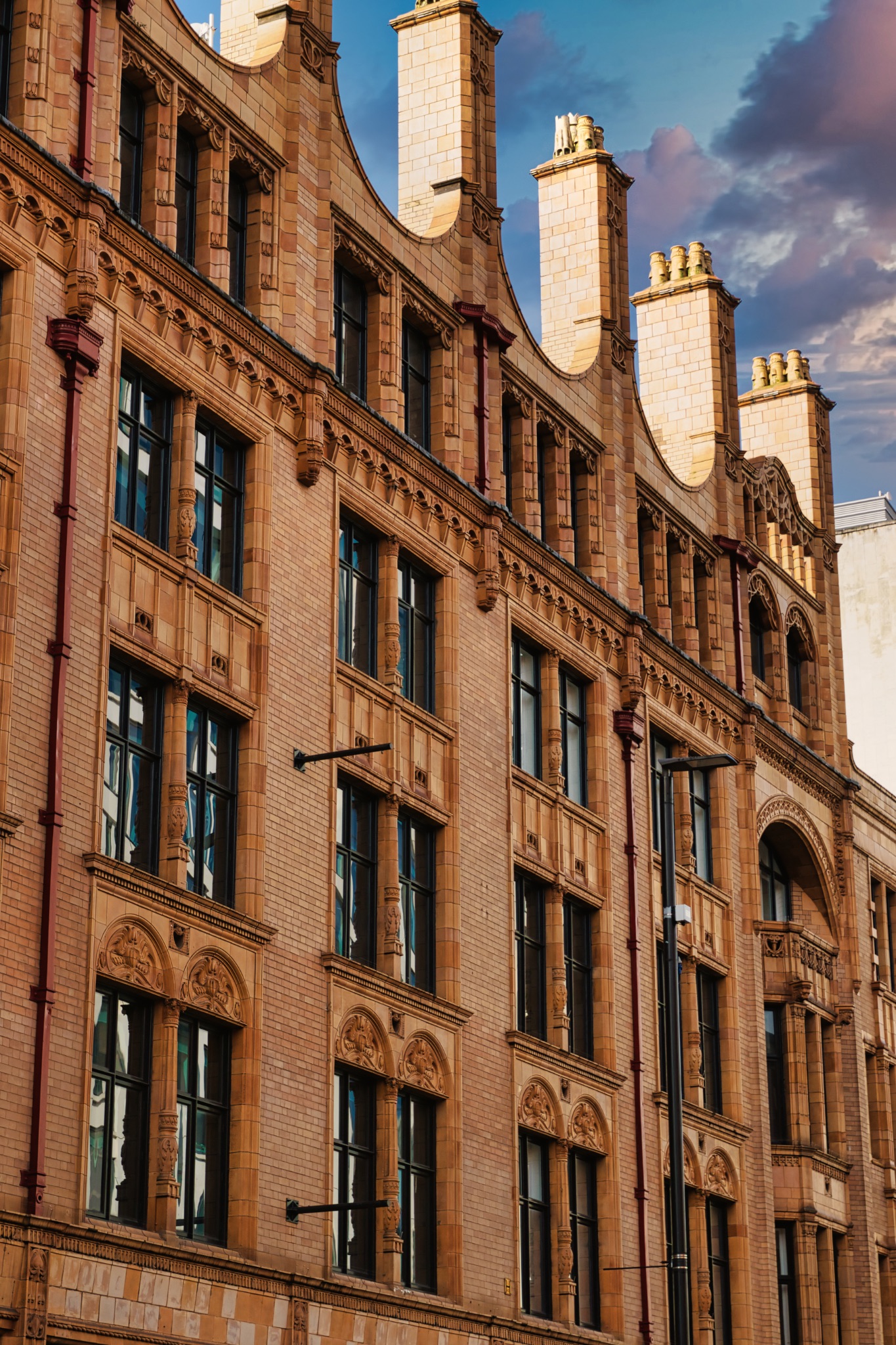 Brick Building with Ornate Detailing and Chimneys in Manchester, UK.